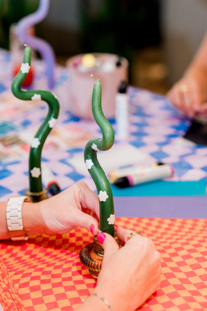 Interactive DIY bendy candle station with guests creating custom candle designs at a corporate summer Dreamland event