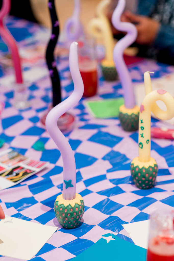 Interactive DIY bendy candle station with guests creating custom candle designs at a corporate summer Dreamland event