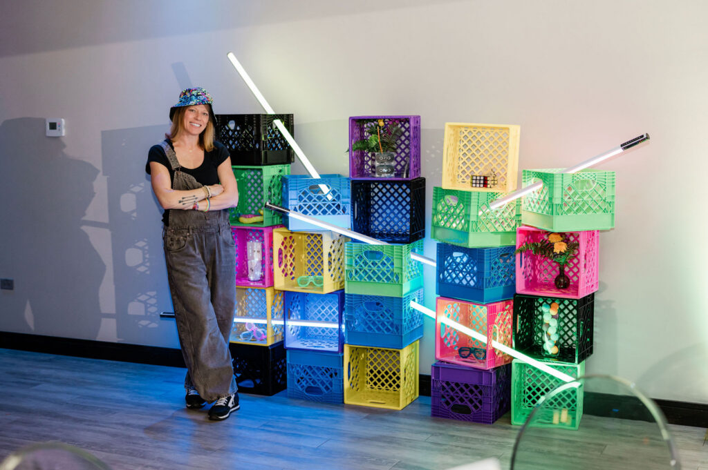 Jessie, the event planner posing in front of one of the decor photo moments of neon crates and light sticks