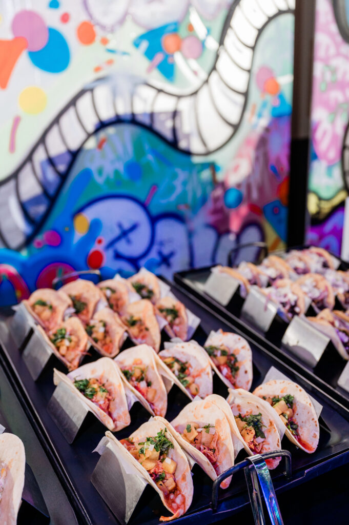 a tray of tacos on a table against a brightly colored wall