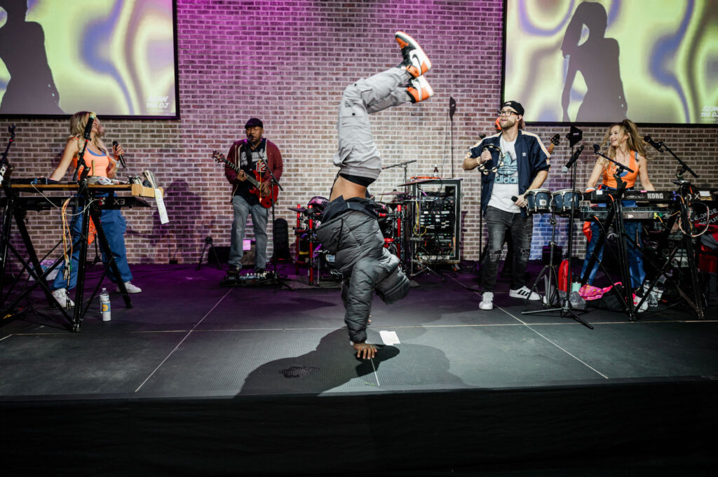 A band member on stage doing a handstand