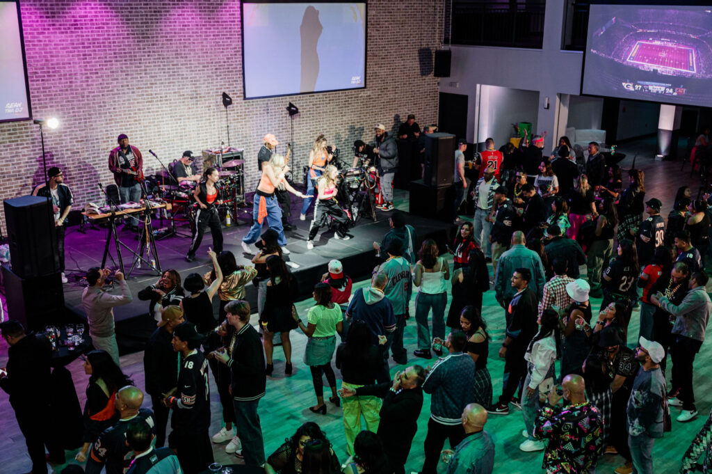 Guests in front of a stage dancing to the band 