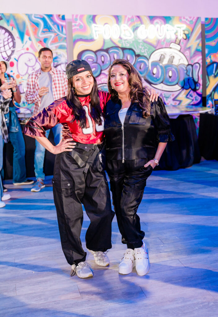 Two women in 80's attire posing for the camera