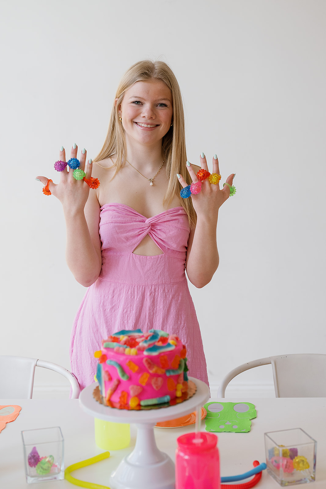 A girl in a pink dress in front of a gummy themed tablescape