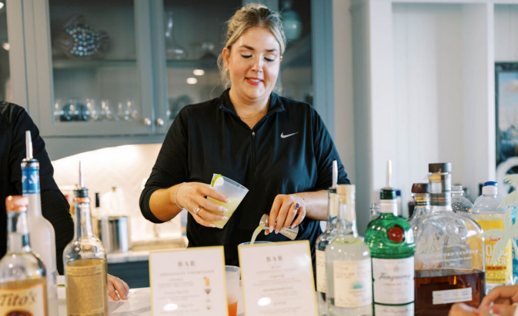 A lady bartender pouring drinks at a bar