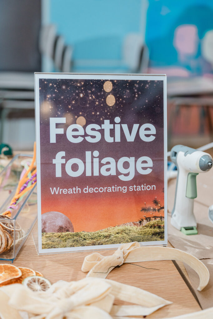 a sign that says festive foliage: wreath decorating station