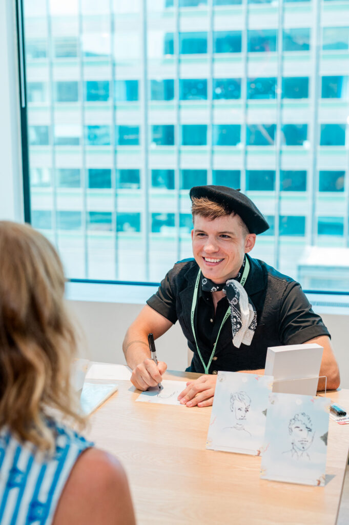 a man smiling and drawing illustrations